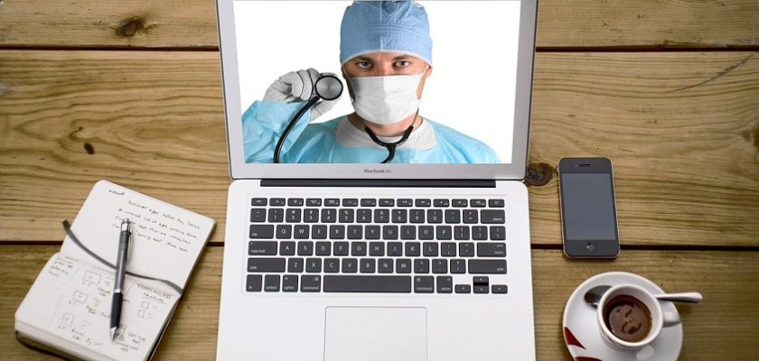A person video chatting with a healthcare professional on a computer screen for virtual urgent care